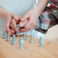 Closeup of man in occupational therapy screwing nut on bolt Closeup on hand of man in occupational therapy screwing nut on bolt